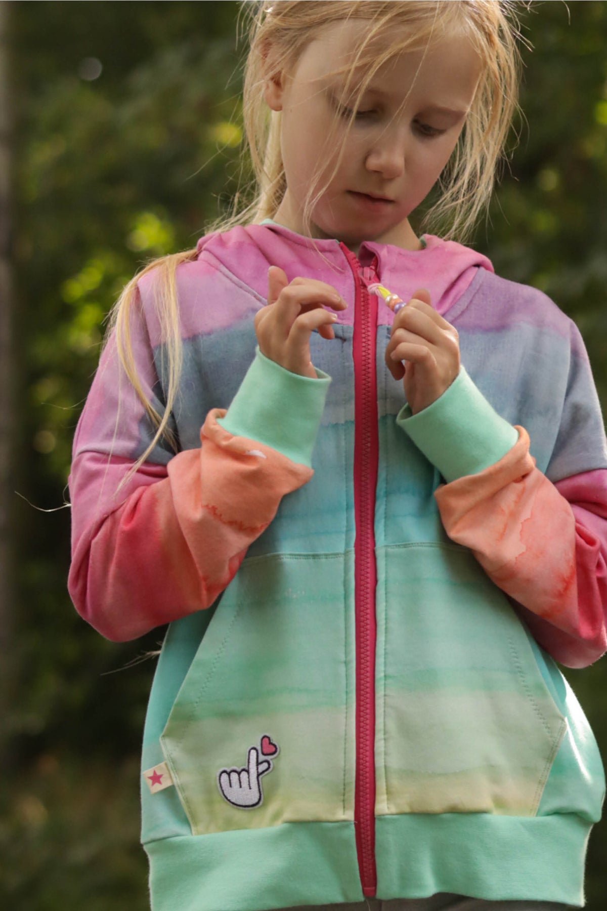 Macadamia-Sweatjacke mit pastellfarbenem Verlauf, Kapuze, pinkem Reißverschluss und Bauchtaschen